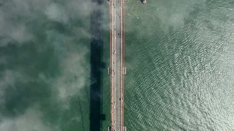 Aerial top view above the clouds over the long road of Golden Gate Bridge with 库存影片 121749892