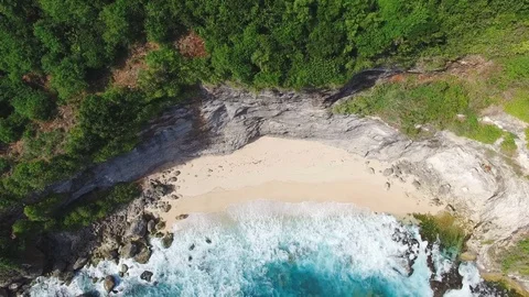 Aerial top view on big ocean waves and hidden paradise beach under big cliff Stock Footage 77556833