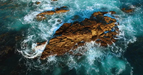 Aerial top view of big waves crashing on a rock in the ocean. Stock Footage 285407725