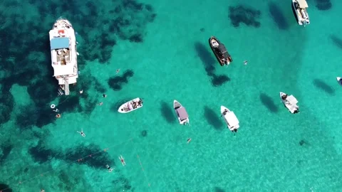 Aerial Top View Blue Lagoon, Turquoise Sea with Boats and Swimmers, Drone Reveal Stock Footage 331037774