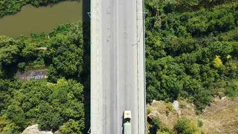 Aerial top view of the bridge of passing cars over a cliff overgrown with trees Stock Footage 138451615