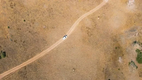 Aerial Top View Car Is Driving On A Dirt Road In A Sunny Desert Stock Footage 161037814