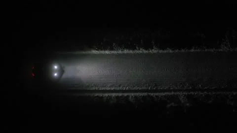 Aerial top view car driving next to a icy forest road at night. Stock Footage