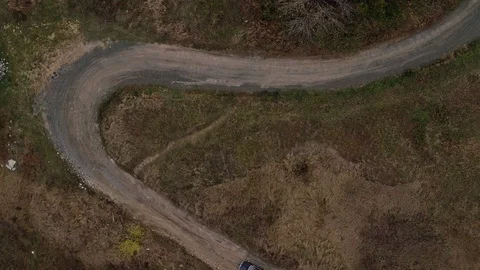 Aerial top view of car going on small road with tight bends 動画素材 100690195