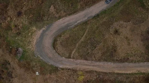 Aerial top view of car going on small road with tight bends Stock Footage 100691714