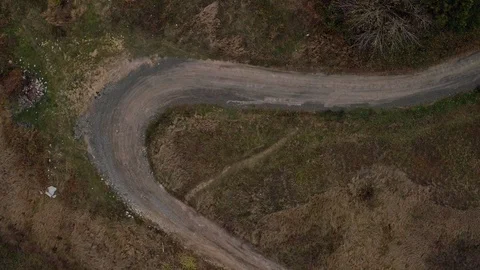 Aerial top view of car going on small road with tight bends Stock Footage 100699144