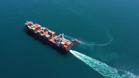 Aerial top view of cargo ship carrying container with contrail in ocean sea Stock Footage 336445687