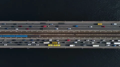 Aerial top view of cars and subway passing the bridge over the river in the city Stock Footage