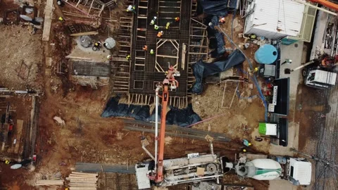 Aerial top view construction workers pouring concrete foundation drone Video stock 333718436
