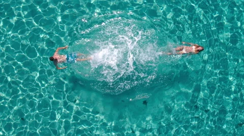 Aerial - Top view of a couple swimming away from each other and making splashes Stock Footage