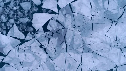 Aerial top view of cracked ice floes. Drone shot flying up over melting ice Vídeo Stock 88692853