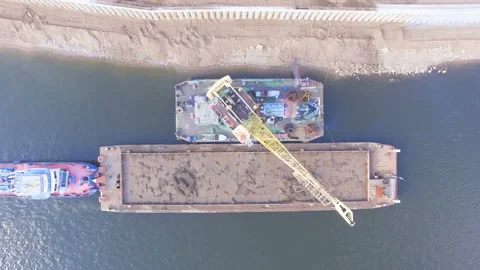 AERIAL: Top view of a crane, unloading a barge with sand. Stock Footage 87062346