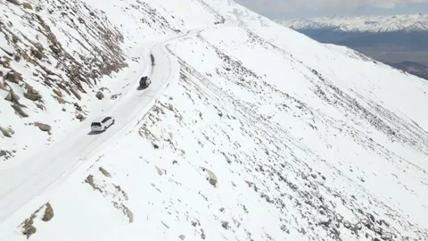 Aerial top view from drone of a camper vehicle driving on snowy ice road with Stock Footage 153848070