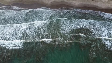 Aerial Top View Drone Footage Of Ocean Waves Reaching Shore Stock Photos