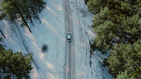Aerial top view from drone of passenger car vehicle driving on snowy ice road in Stock Footage 148369161