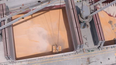 Aerial top view of a large crane loading grain into a bulk carrier ship at a Stock Footage 345525217