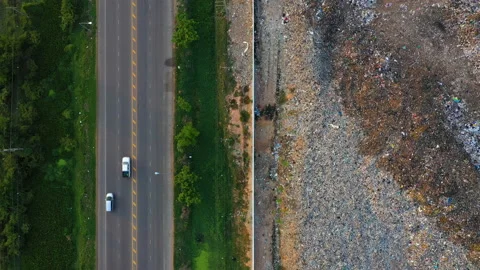 Aerial top view, large garbage pile at sorting site with roadway. Zoom out Stock Footage 141589096