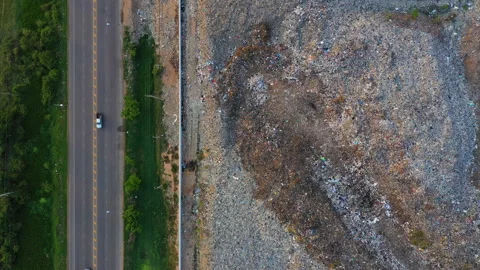 Aerial top view, large garbage pile at sorting site with roadway. Dolly Stock Footage 153421308