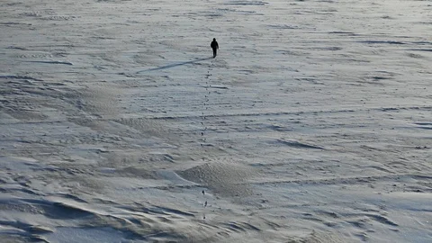 Aerial top view of a man with a backpack walking by the tundra. Video stock 123158213