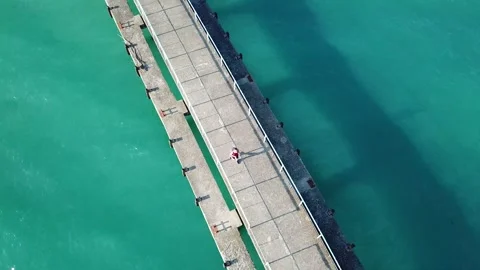 Aerial top view, man is walking along the pier in Pitsunda, Abkhazia. Stock Footage 321378190