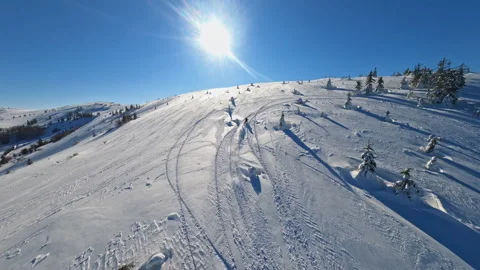 Aerial top view in mountains guy on snowmobile jumps and rides in the winter at Stock Footage 197486568