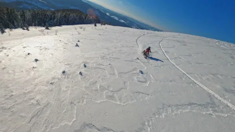 Aerial top view in mountains two guys on snowmobile jumps and rides in the Stock-Footage 189409929