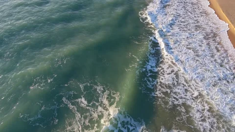 Aerial top view ocean waves breaking along sandy beach shoreline Stock Footage 328142835