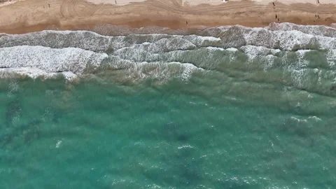 Aerial top view of ocean waves hitting sandy beach coastline Stock Footage 332571209