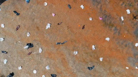 Aerial top view of plastic trash dumped on the banks of a dry and polluted river Video stock 122846282
