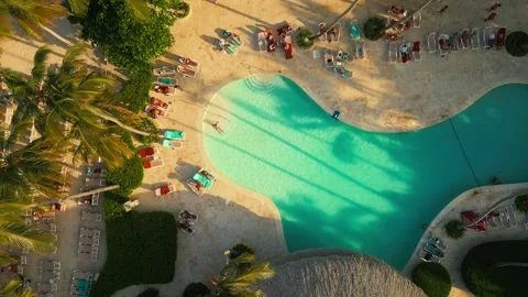 Aerial top view of pool. Sunset warm, light over everything. Tourists relaxing Video stock 305556417