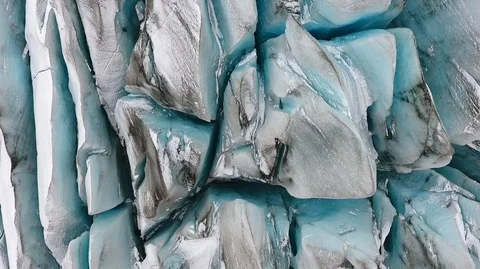 Aerial top view of the ridges of white glacier with black ash. Scenic iceberg in Stock Footage 120300862