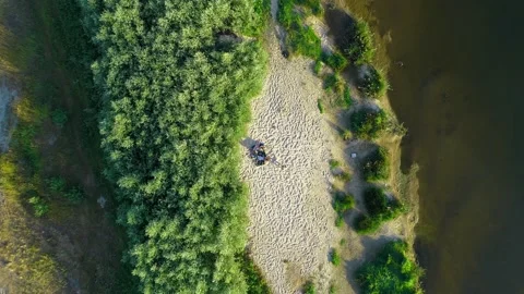 Aerial top view river, trees. On the beach people men and girls are sunbathing Video stock 135298565