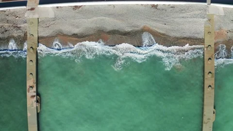 Aerial top view of sandy beach coastline with breakwaters and azure sea water in Video stock 149945682