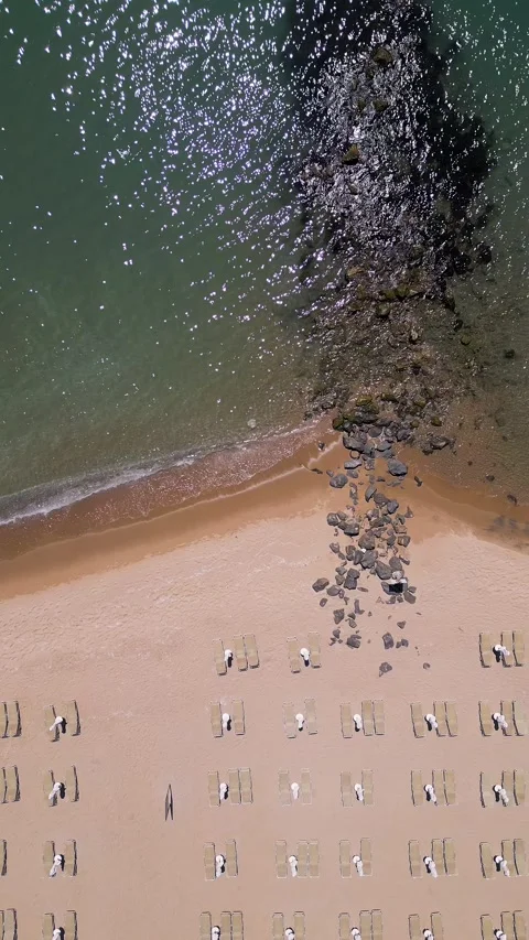 Aerial top view of sandy beach with breakwater and sunbeds Vídeos de archivo 336949573