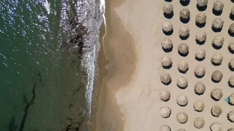 Aerial top view of sandy beach with straw umbrellas and sea waves Vídeo Stock 336953660