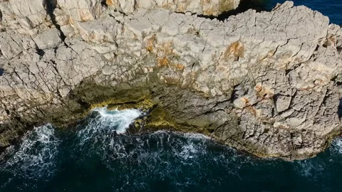 Aerial top view: sea waves wash the rocky coastline Stock Footage 111116670