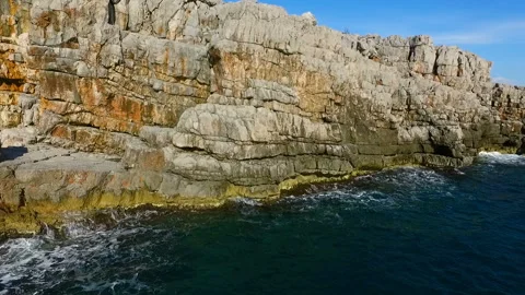Aerial top view: sea waves wash the rocky coastline Stock Footage 111138432