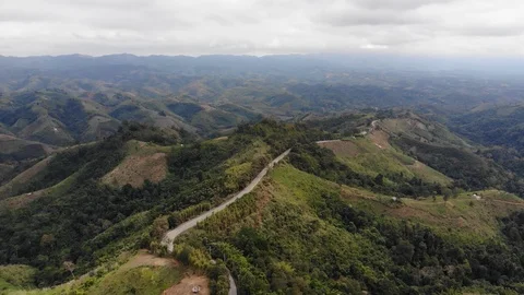 Aerial top view of sky road over top of mountain green jungle Vidéo 106664243
