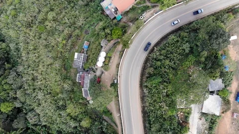 Aerial top view of sky road over top of mountain green jungle Stock Footage 106935797