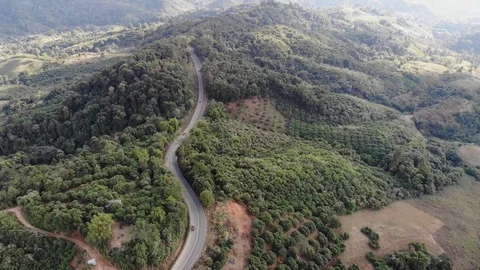Aerial top view of sky road over top of mountain green jungle Stock Footage 106935969