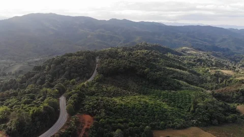 Aerial top view of sky road over top of mountain green jungle Stock Footage 106936152