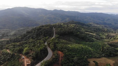 Aerial top view of sky road over top of mountain green jungle Stock Footage 106936221