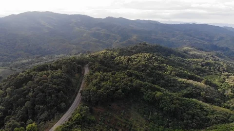 Aerial top view of sky road over top of mountain green jungle Stock Footage 106936236