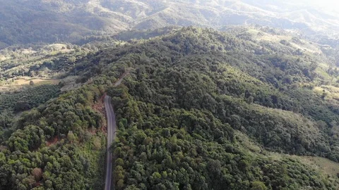 Aerial top view of sky road over top of mountain green jungle Stock Footage 106936505