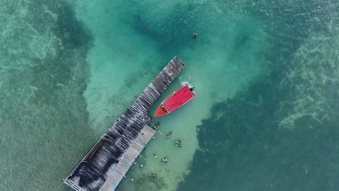Aerial top of view of a small red boat reaching the wooden pier, Martinique 動画素材 82658743