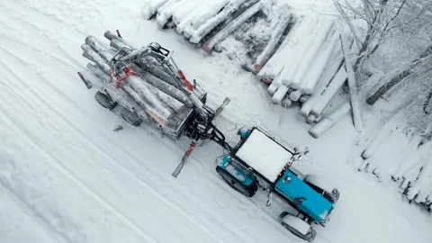 Aerial top view tractor with a crane  snow-covered forest Stock Footage 169548411