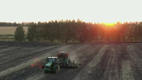 Aerial Top view, tractor plants spring wheat at sunset, sowing winter crops Stock Footage 158256221