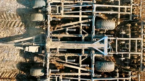 Aerial top view A tractor plows a field with a plow close up. Preparation of the Stock Footage 243267563