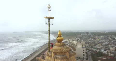 Aerial top view of trisula and man hosting flag in the head of Somnath Stock Footage 195308220