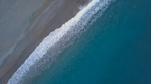 Aerial top view waves break on beach drone rotation above blue ocean waves Stock Footage 111017076